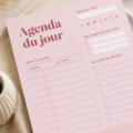 Femme souriante planifiant sa journée avec un agenda moderne sur une table en bois